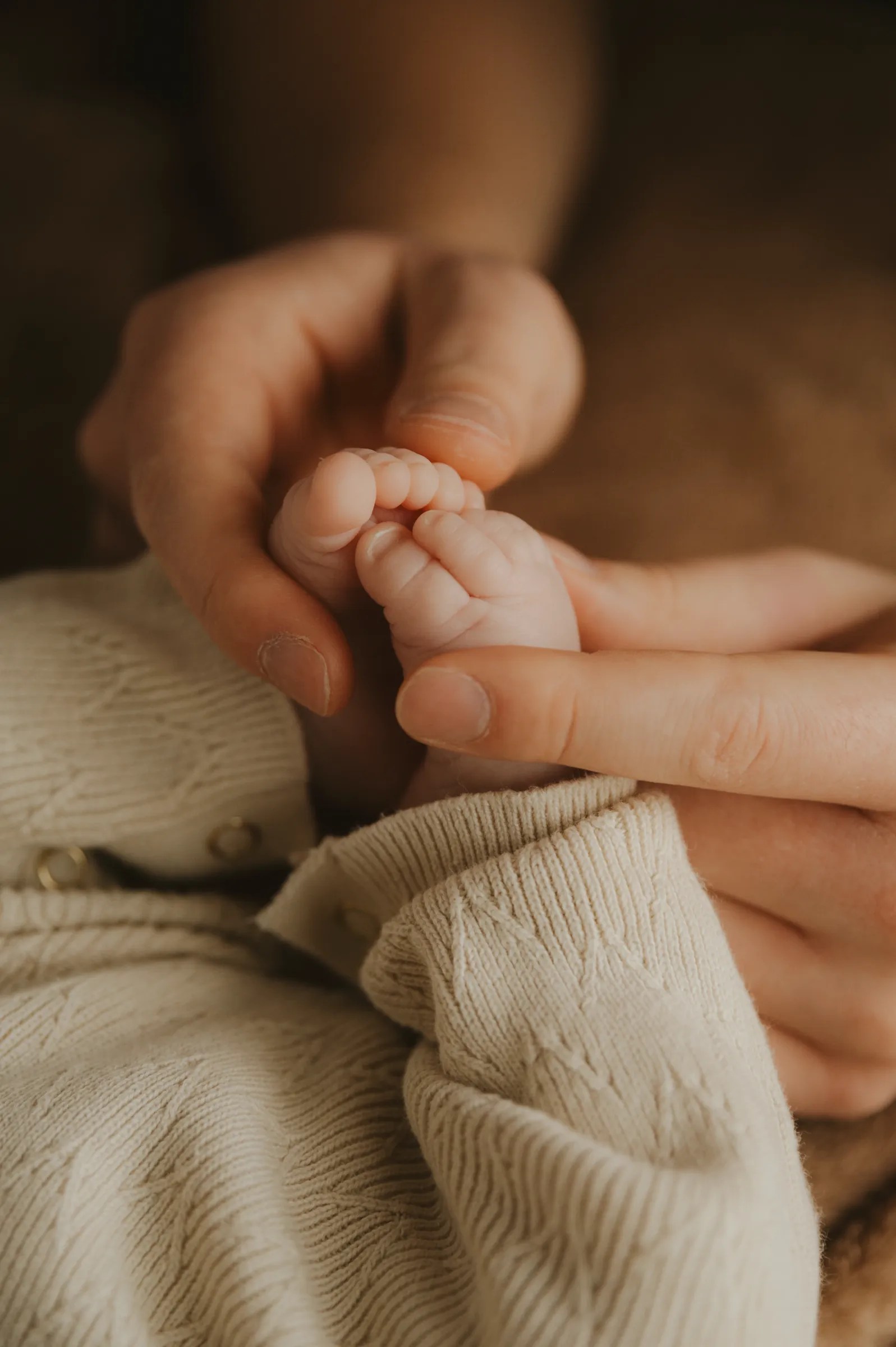 Vader houdt de kleine voetjes vast van zijn pasgeboren, newborn baby.